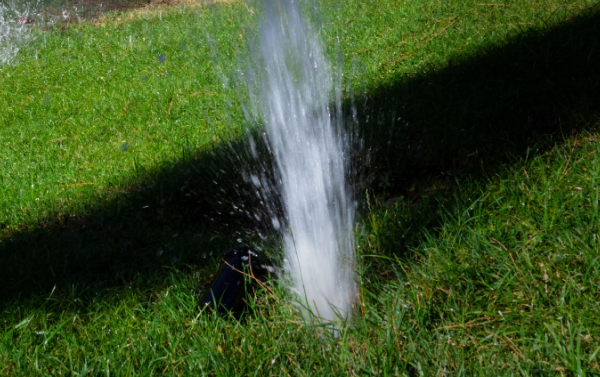 broken sprinkler with water spraying out